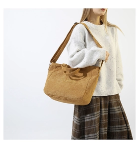Detail of a brown corduroy tote bag with Fashion embroidery and adjustable strap