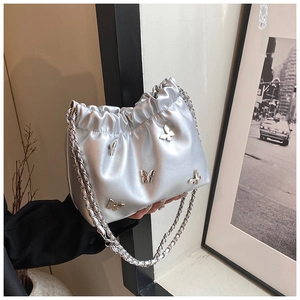 Detailansicht der silbernen Metallic-Eimertasche mit glänzenden Schleifen-Elementen