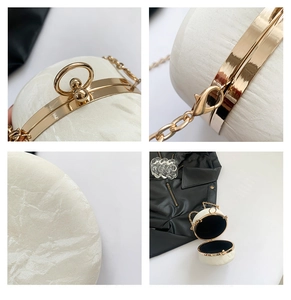 Detailed macro view of cream circular shell clutch bag with pearl texture and gold ring