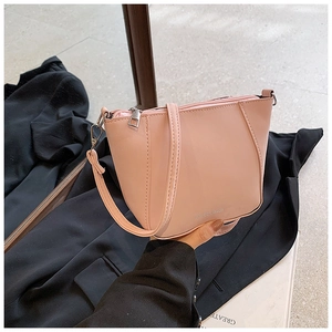 Dettaglio della borsa a tracolla trapezoidale rosa con cerniera e tracolla fine