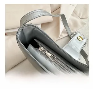 Détail du zip métallique fluide sur le sac baguette argenté en similicuir