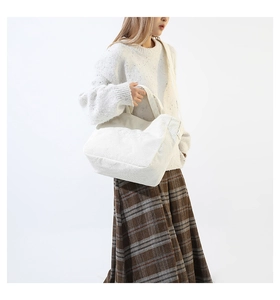 Detail of white corduroy tote bag showing soft ribbed texture and adjustable strap