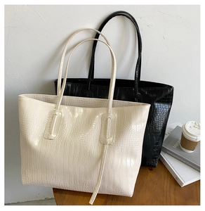 Gros plan de sacs cabas minimalistes à motif crocodile en beige et noir élégant