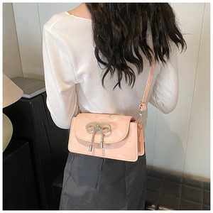 Pink crossbody square bag with a sparkling rhinestone bow and stylish metal tassels