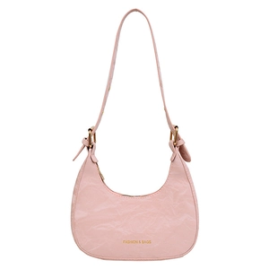 Pink crescent underarm bag with ruched texture and adjustable strap on white background
