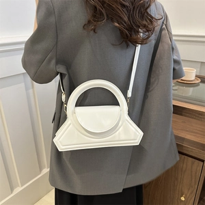 Borsa a mano bianca trapezoidale con grande manico ad anello indossata da modella