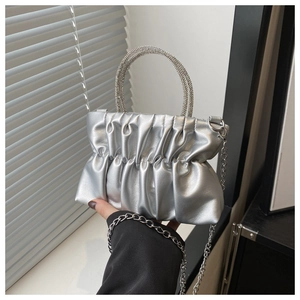 Detail of silver pleated bag with a crystal-embellished ring handle and metallic chain