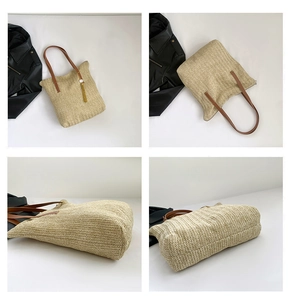 Detail view of woven straw tote bag with brown leather handles and decorative tassel pendant