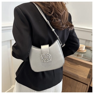 Detail of silver shoulder bag with sparkling crystal buckle and sleek faux leather finish