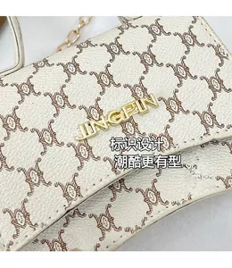 Detail of creamy white textured leather bag with cat prints and golden JINGPIN logo