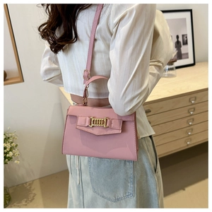 Detail of pink PU leather crossbody bag featuring gold chain buckle and adjustable strap