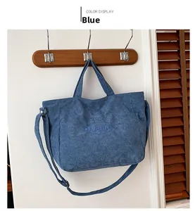Detailed macro view of the blue corduroy fabric texture and Fashion embroidery on tote bag