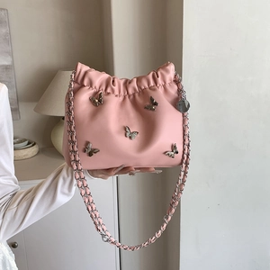 Rosa Plissee-Beuteltasche mit silbernen Schmetterlingen und Kettenriemen im Lifestyle-Look