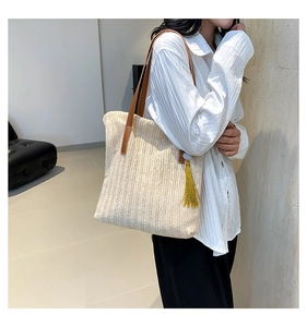 Detail of chevron straw weave texture and yellow tassel on cream shoulder bucket bag