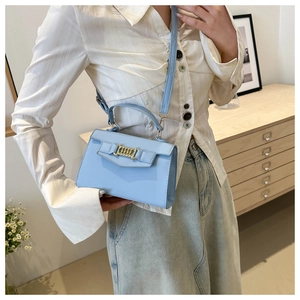 Borsa a tracolla azzurra con catena dorata e manico mostrata in uno scatto lifestyle