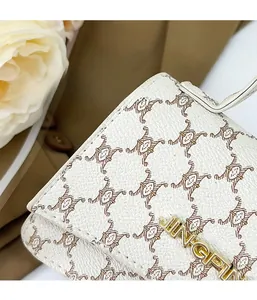 Detail of white litchi grain texture and vintage brown geometric patterns on handbag