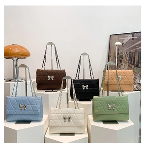 Détail de sacs matelassés à chaîne avec nœud métallique en plusieurs tons pastel