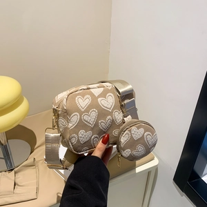 Beige canvas shoulder bag with heart pattern and matching coin purse charm