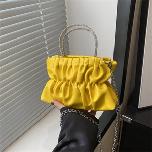 Bright yellow pleated cloud bag with a sparkling diamond handle and silver chain strap