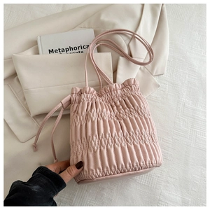Detailed view of pink drawstring bucket bag with elegant pleated texture and thin strap