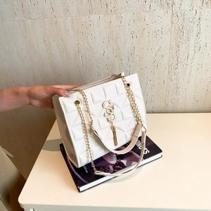 White quilted tote bag with gold chain strap, metal logo and stylish tassel detail