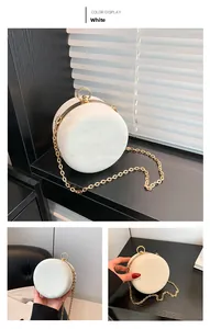 Detail view of white marble evening bag with gold metal frame and ring handle