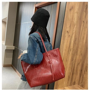 Détail du grand sac cabas rouge à motif crocodile avec de longues anses pour le porter