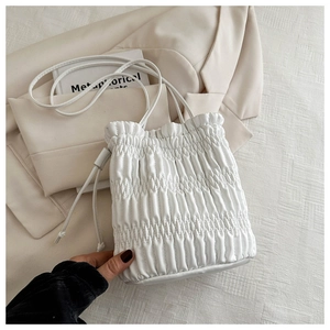 Detailed top view of a white drawstring bucket bag with pleated texture and soft leather finish