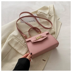Detail of pink leather flap bag with gold chain link buckle and adjustable strap