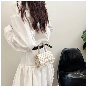 Detail of elegant beige vintage crossbody bag with gold chain strap and metal logo
