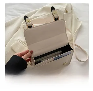 Detail showing internal compartments of the beige crossbody bag with smartphone and cards