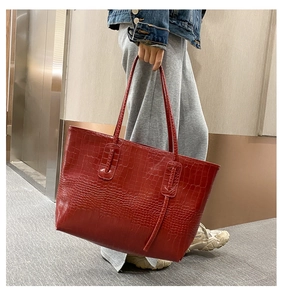 Détail de la texture crocodile rouge sur un grand cabas avec finition brillante