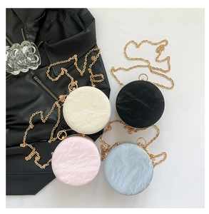 Top view of mini round chain bags in black, beige, pink and blue with marble texture