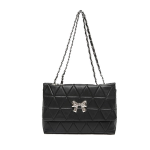 Quilted black shoulder bag featuring a silver metal bow and dual chain strap on white background