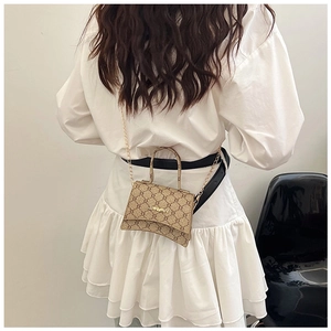 Model view of khaki monogram mini bag with gold chain strap and curved handle