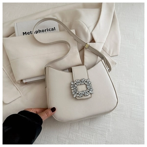 Détail du sac baguette blanc crème avec boucle carrée en cristal de luxe sur tissu