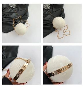 Detail of spherical evening bag in creamy white with gold chain and marble texture finish
