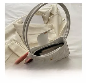 Vista interna que muestra la capacidad del bolso acolchado blanco con bolsillo interior
