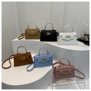 Collection of six elegant leather handbags in various colors displayed on white steps