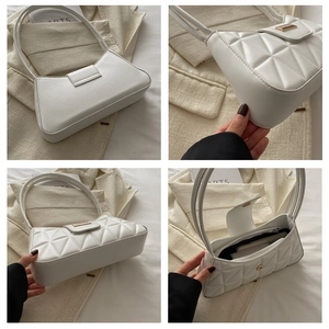 Detalle del bolso de hombro blanco con textura geométrica y hebilla metálica dorada