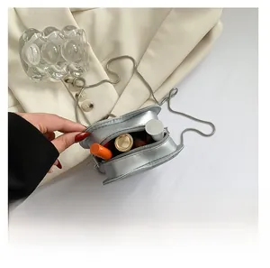 Detail showing the mini silver heart bag interior capacity with metal snake chain