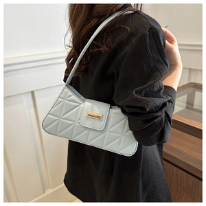 Detail of light blue quilted shoulder bag with elegant gold metal buckle and leather strap