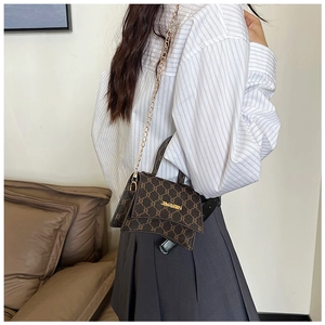 Detail of vintage brown monogram bag with hourglass shape and gold chain strap