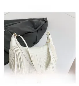 Détail du sac à franges blanc avec texture grainée et boucles métalliques dorées
