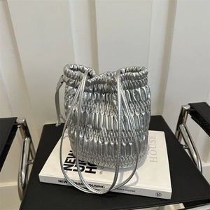 Chic silver metallic pleated bucket bag with quilted details and long drawstring straps
