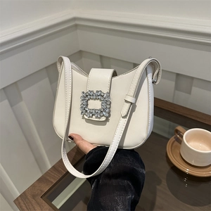 Sac sous le bras croissant blanc crème avec boucle en cristal dans un cadre café