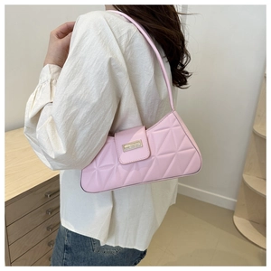 Detailed view of pink quilted shoulder bag featuring geometric stitching and metal clasp