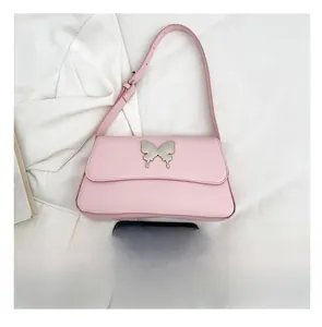 Rosa Schultertasche mit Schmetterlingsschnalle und Smartphone zum Größenvergleich