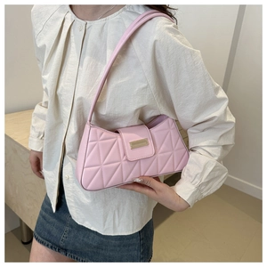 Light pink quilted baguette shoulder bag with gold clasp shown on a model