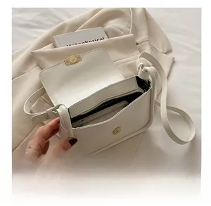 Interior view of beige leather shoulder bag showing smartphone compartment and zipper pocket
